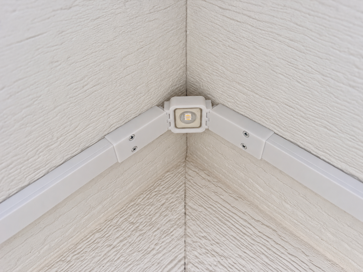White Govee non-Pro gable bracket installed under a roof peak with a permanent outdoor LED light and wire channels.