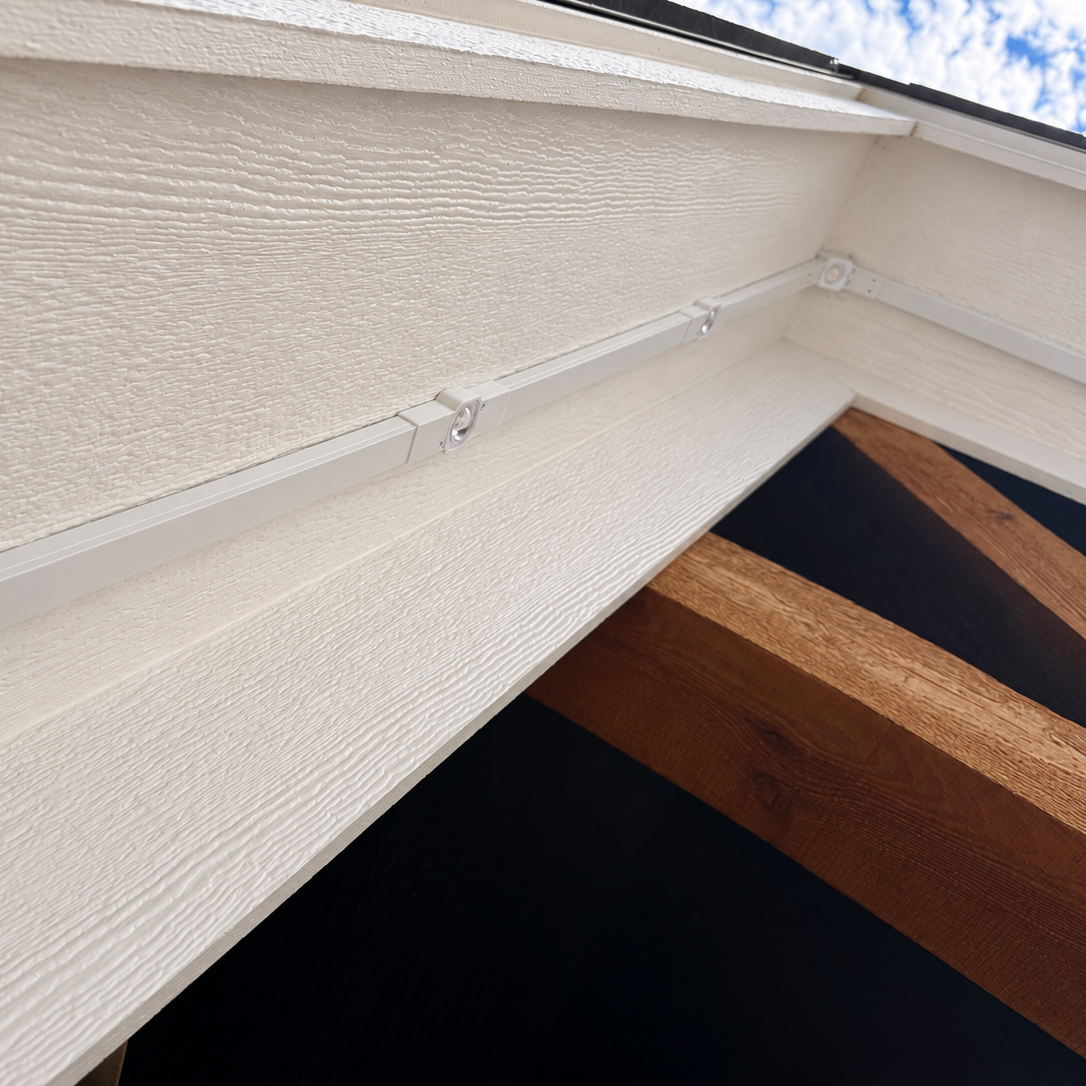 Angled view of white Govee Pro light channels mounted along a sloped gable soffit with a Peak Hinge bracket.