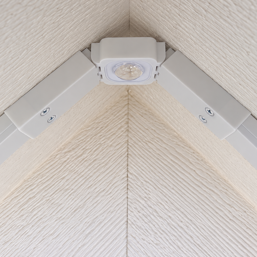 Close-up of a white Govee Pro Channel Fit Peak Hinge with an installed LED light beneath a gable roof peak.