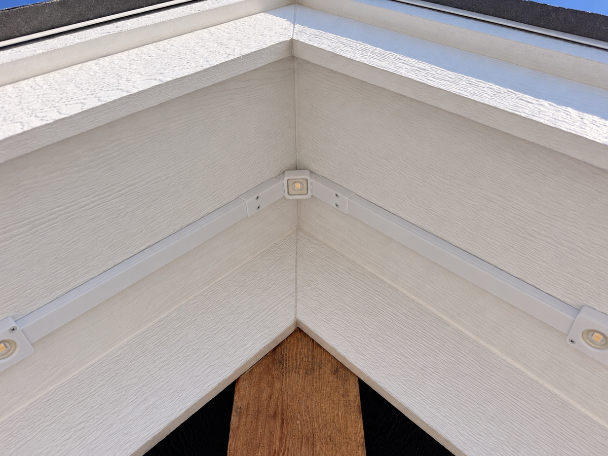 Exterior view of Govee non-Pro permanent outdoor lights mounted along a house gable using a white roof peak bracket and channels.