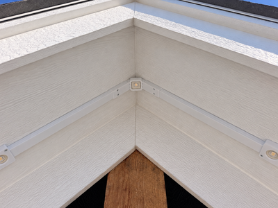 Exterior view of Govee non-Pro permanent outdoor lights mounted along a house gable using a white roof peak bracket and channels.
