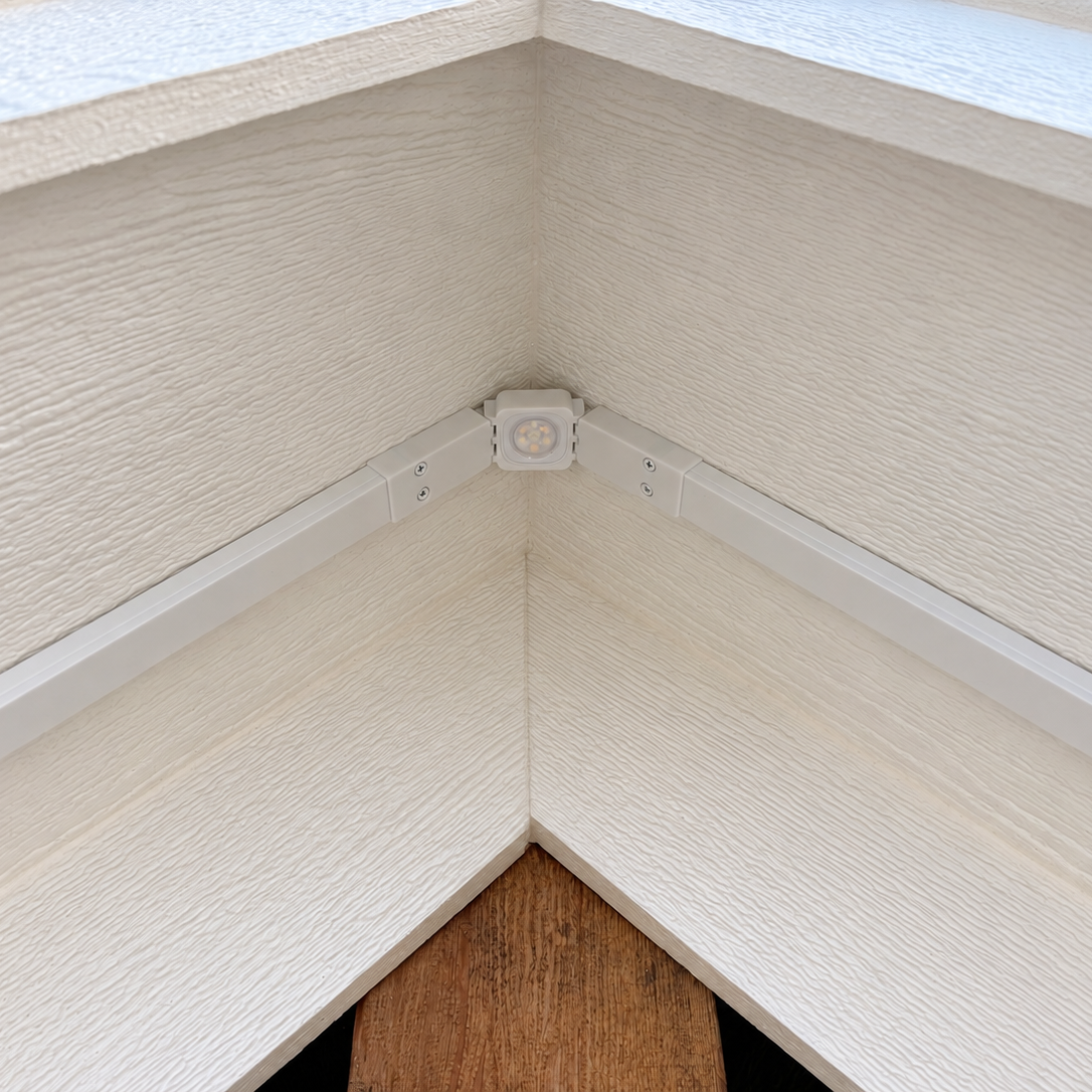 White Govee Pro Channel Fit Peak Hinge installed under a house gable, connecting light channels at the roof peak.